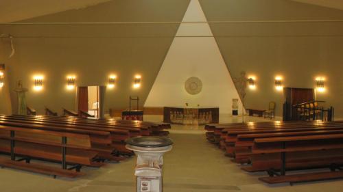 an empty church with a bunch of wooden pews at Hotel Oasi Dei Discepoli in Orvieto
