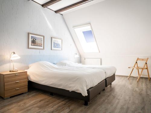 ein Schlafzimmer mit einem großen Bett und einem Fenster in der Unterkunft Great Farmhouse in De Cocksdorp with Garden in De Cocksdorp