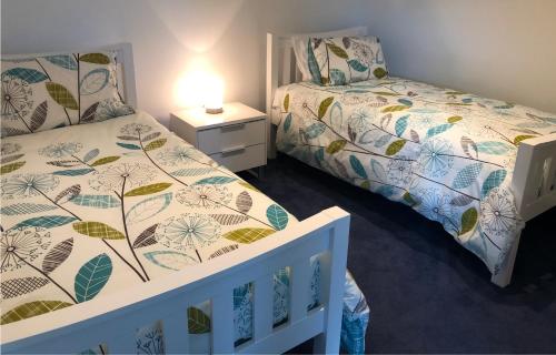 a bedroom with two beds and a crib and a lamp at 130 At The Waves in Cowes