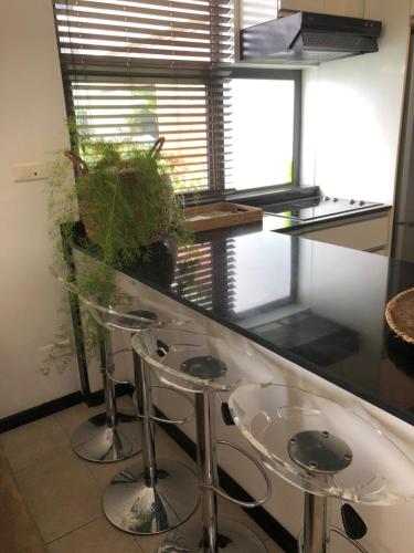 a kitchen with two stools and a counter with a window at Beach Apartment - Trou aux Biches - Ground Floor in Mont Choisy