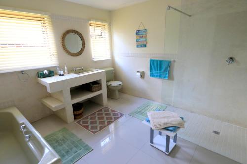 a bathroom with a sink and a shower at Menlo At C in Plettenberg Bay