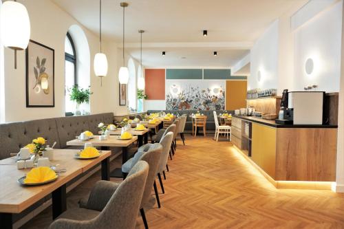a restaurant with long tables and chairs and a kitchen at dieSonne in Weimar