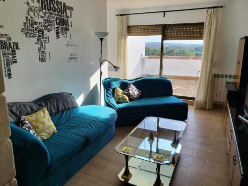 a living room with two blue couches and a table at LA GATERA 1D BAJO ARAGON - MATARRAÑA in Fabara