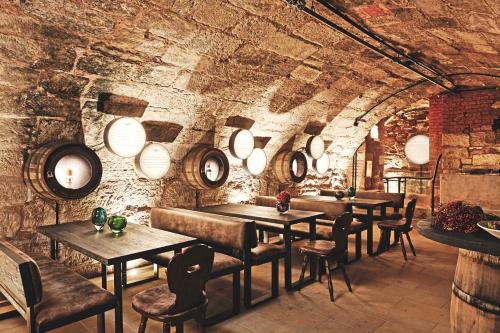 a restaurant with wooden tables and chairs and a brick wall at Zum Löwen Design Hotel Resort & Spa in Duderstadt