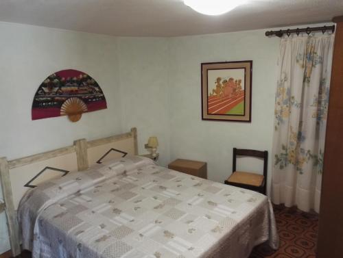 1 dormitorio con 1 cama con colcha blanca en Appartamento Villa Edera, en Baja Sardinia