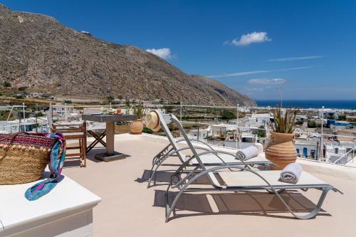 a patio with chairs and a view of a city at Nalas Suites in Emporio Santorini