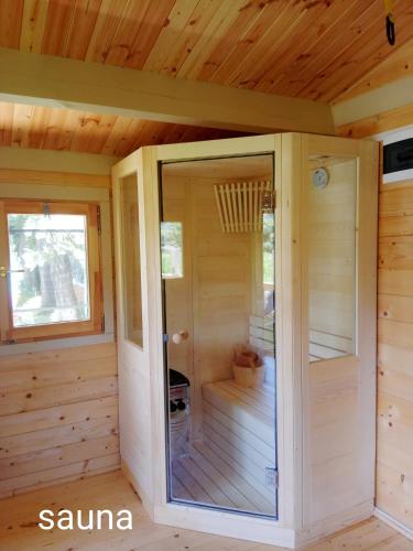 a sauna with a glass door in a cabin at Cormoranos Apartments Rooms Eco Green in Kissamos