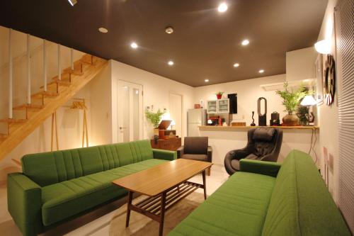 a living room with a green couch and a table at Fuji Time traveler 新館 in Fujikawaguchiko