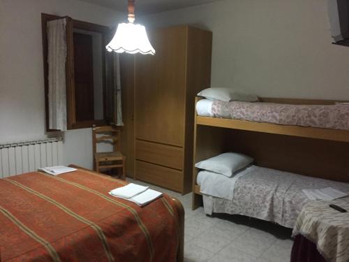 a hotel room with two beds and a lamp at Locanda del Sole in Montese