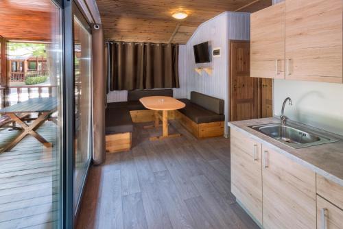 a kitchen and dining area of a tiny house at Camping Solmar in Blanes