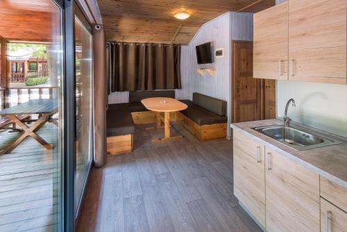 Una pequeña casa con cocina y zona de comedor en Camping Solmar, en Blanes