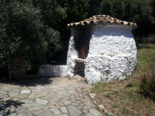 un pequeño edificio de piedra con techo en un patio en CASA EL CERRO, en El Bosque