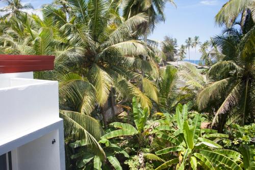 a view from the balcony of a resort with palm trees at Alvas house in Hikkaduwa