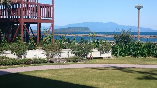 a garden with a large tower and the water at Fufurotenburonoyado Ginsyou in Ibusuki