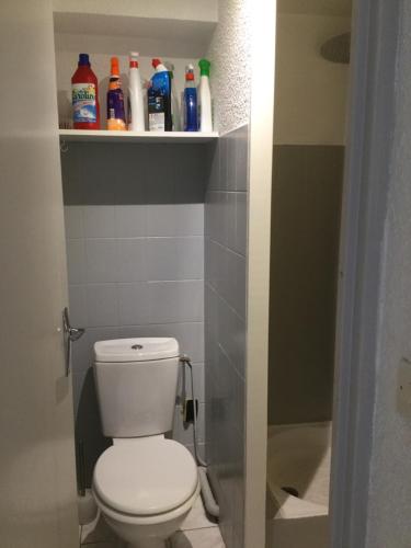 ein Badezimmer mit WC und Flaschen auf einem Regal in der Unterkunft Studio cabine Toi et Moi à 30 m de la plage de Valras centre in Valras-Plage