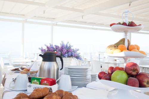 a table topped with plates of fruit and croissants at White Bay in Fontane Bianche