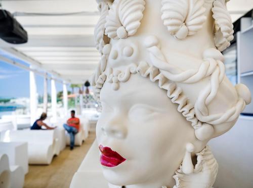 a statue of a woman with red lipstick at White Bay in Fontane Bianche