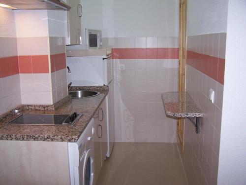 uma pequena cozinha com um lavatório e uma bancada em ESTUDIO CON PISCINA Y GARAJE A 100 Mtr DE LA PLAYA em Isla Cristina