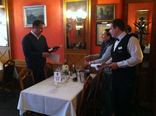 a group of people standing around a table in a restaurant at Hotel Concertino Zlatá Husa in Jindrichuv Hradec