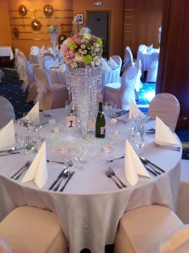 a table set up for a wedding with a bottle of wine at Hotel Concertino Zlatá Husa in Jindrichuv Hradec