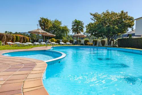 uma piscina com água azul num resort em Hotel Turimar em Sanxenxo