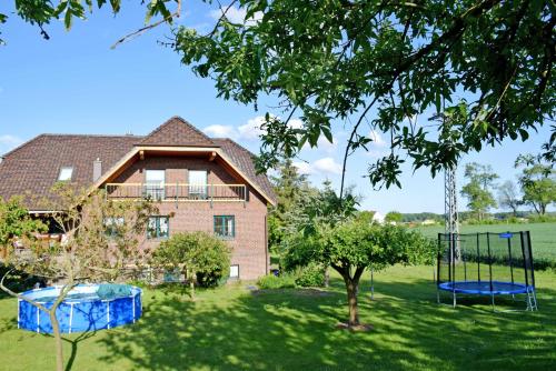 ein Haus mit einem Hof mit Schaukel in der Unterkunft Ferienwohnung Zudar auf Rügen in Zudar