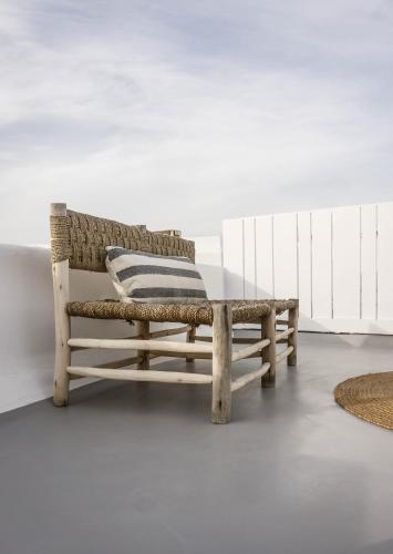 a wooden bench with a pillow on top of a table at Roofs Of Chora in Mikonos