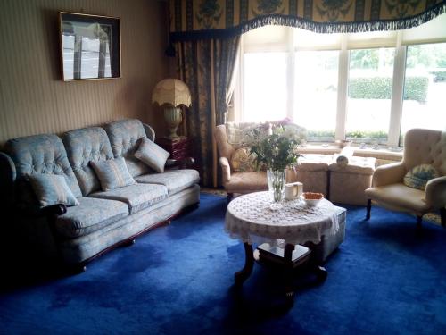 a living room with two couches and a table and a window at Rosemount B&B in Dundalk