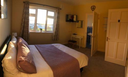 a hotel room with a bed and a window at The View in Lahinch
