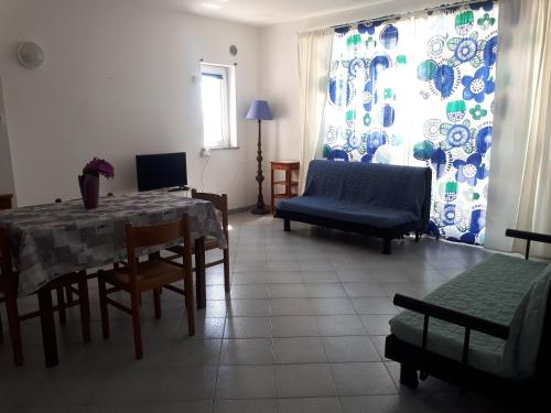sala de estar con mesa, sillas y sofá en Appartamenti Varaldo & Elena CITR 008O67, en Villa Faraldi