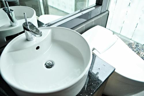 a bathroom with a white sink and a toilet at Shuian Lakeside Hotel in Yuchi