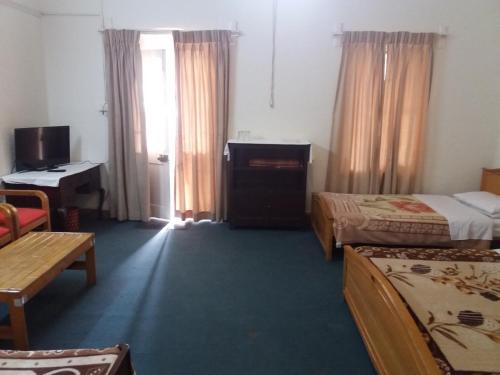 a hotel room with two beds and a television at BRIGHTLANDS HOTEL in Murree