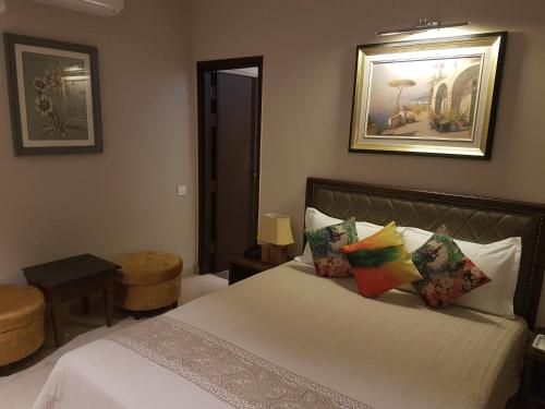 a bedroom with a white bed with colorful pillows at Hotel Kasauli Regency Stags Not Allowed in Kasauli