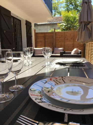 une table avec des verres et une assiette dans l'établissement Le Charme des Dunes, à Arcachon