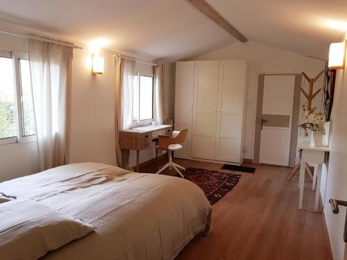 1 dormitorio con cama, escritorio y ventana en Charmante maisonnette indépendante à Goult en Luberon, en Goult