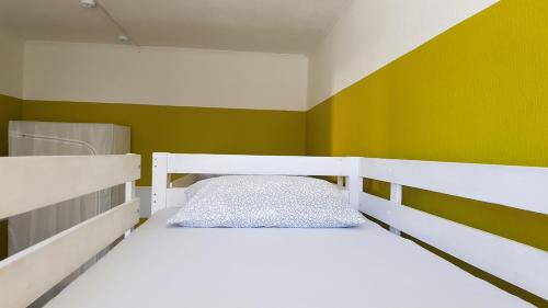 ロストフ・ナ・ドヌにあるGuest House Rostovの緑の壁のベッドルーム1室(白いベッド1台付)