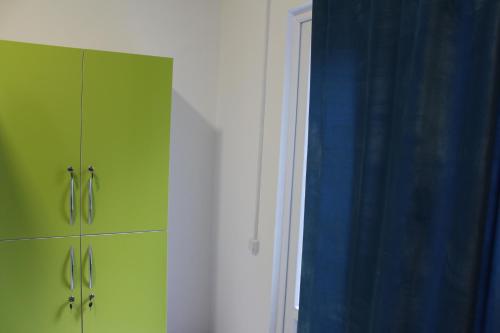 a green cabinet and a blue curtain in a room at Park Hostel Osh in Osh