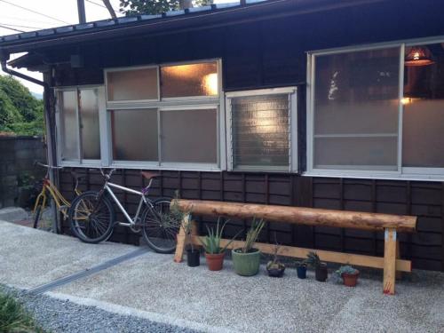a bike parked next to a house with a bench at Mt Fuji Historical Oshi house hitsuki in Fujiyoshida