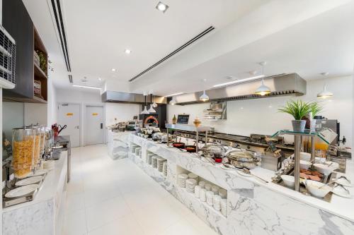 a kitchen with a long counter in a restaurant at Citymax Hotel Al Barsha in Dubai