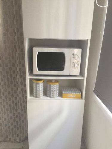 a microwave oven sitting on top of a shelf at Studio centre avec terrasse in Avignon
