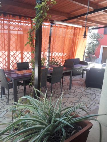 a patio with a table and chairs and plants at Domu de Palla- IUN-E5167 in Bauladu