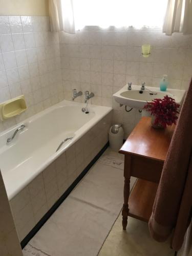 a bathroom with a bath tub and a sink at Rosewood Corner, Clarens in Clarens