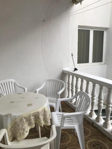 una mesa y sillas blancas en una habitación con ventana en Miron apart&rooms, en Rafailovici