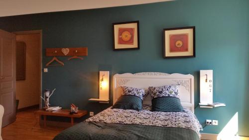 1 dormitorio con 1 cama con pared azul en clos st Joseph, en Oullins