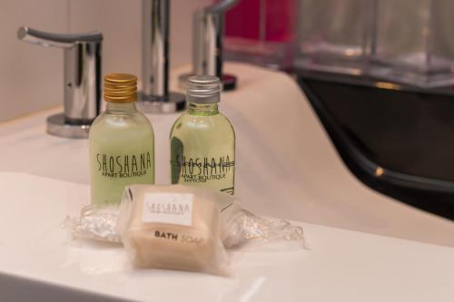 two bottles of vinegar sitting on a kitchen sink at Shoshana Hotel Boutique in Buenos Aires