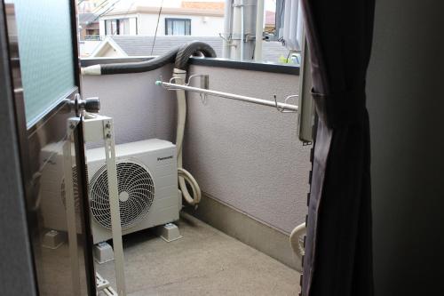 a room with a heater and a fan at マンションロアジス 大阪市東淀川区相川 in Osaka
