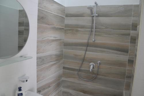 y baño con ducha y azulejos de madera. en Lungomare 2 en Procida