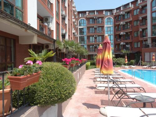a row of chairs and umbrellas next to a pool at Chateau del Marina Apart Complex in Nesebar