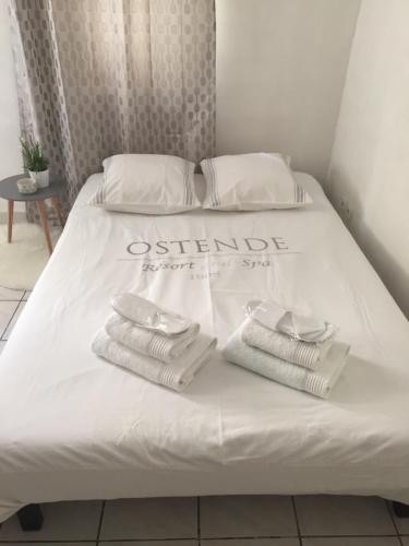 - un lit avec des draps blancs et des serviettes pliées dans l'établissement Studio centre avec terrasse, à Avignon
