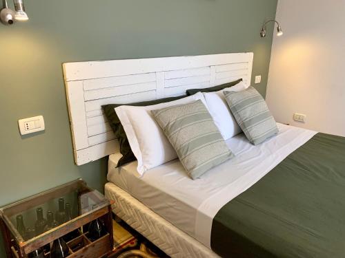 a bedroom with a bed with a white headboard and pillows at Porta Ronca - B&B, Suites & Apts in Rho